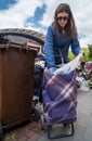 Young woman putting vegetables from the garbage in her shopping cart to recycle and feed her chickens helping sustainable,