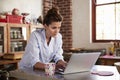 Young woman in pyjamas using laptop in kitchen, close up Royalty Free Stock Photo