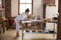 Young woman in pyjamas using laptop in kitchen, full length Royalty Free Stock Photo