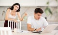 Young woman quarrels with young guy working at laptop Royalty Free Stock Photo