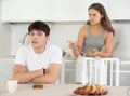 Young woman quarrels with young guy in kitchen Royalty Free Stock Photo