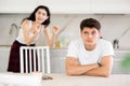 Young woman quarrels with young guy in kitchen Royalty Free Stock Photo