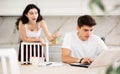 Young woman quarrels with young guy working at laptop Royalty Free Stock Photo