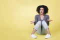 Young woman with questioning look isolated on yellow background.