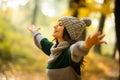 Young woman with raised hands enjoy autumn sunny weather in park Royalty Free Stock Photo