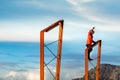 young woman raised on a metal tower waving her hand, freedom concept