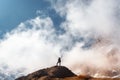 Young woman with raised up arms on the mountain peak