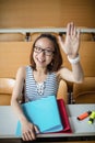 Young woman raising hand in classroom Royalty Free Stock Photo