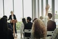 Young woman raising hand up to ask question with speaker in the meeting room seminar conference Royalty Free Stock Photo