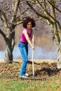 Young woman with a rake in an orchard Royalty Free Stock Photo