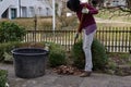 Young woman is raking leaves with garden rake in springtime. Royalty Free Stock Photo