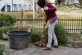 Young woman is raking leaves with garden rake in springtime Royalty Free Stock Photo