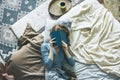 Young woman reading book on bed in loft room, slow life