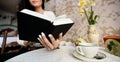 Young woman reading book in cafe Royalty Free Stock Photo