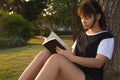 Young woman reading book. Closeup of a beautiful young woman reading book at park. Royalty Free Stock Photo