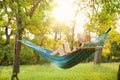 Young woman reading book in comfortable hammock at garden Royalty Free Stock Photo