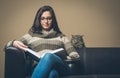 Young woman reading a book with curious cat Royalty Free Stock Photo