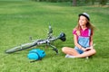 Young woman reading a book after cycling at the local park