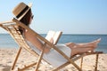 Young woman reading book in deck chair Royalty Free Stock Photo