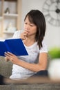 young woman reading book and frowning Royalty Free Stock Photo
