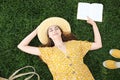 Young woman reading book on green grass, top view Royalty Free Stock Photo