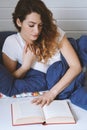 young woman reading book while lying in bed Royalty Free Stock Photo