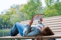 Young woman reading a book lying on the bench Royalty Free Stock Photo