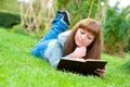 Young woman reading a book lying on the grass Royalty Free Stock Photo