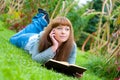 Young woman reading a book lying on the grass Royalty Free Stock Photo