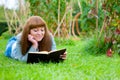 Young woman reading a book lying on the grass Royalty Free Stock Photo