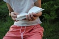 Young woman reading a book outdoors. Close-up of hands holding a book. Summer sunny day. Royalty Free Stock Photo