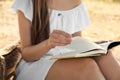 Young woman reading book outdoors, closeup Royalty Free Stock Photo