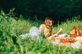 Young woman reading book outdoors, in natural park on picnic, lying on a picnic blanket and enjoying summer weather Royalty Free Stock Photo