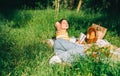 Young woman reading book outdoors, in natural park on picnic, lying on a picnic blanket and enjoying summer weather Royalty Free Stock Photo