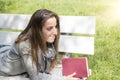 Young woman reading a book on a park bench Royalty Free Stock Photo