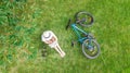 Young woman reading book in park near bike. Student girl relaxing outdoors sitting on grass with bicycle, book and headphones Royalty Free Stock Photo