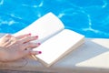 Young woman reading book at pool