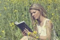 Young woman reading a book on the meadow Royalty Free Stock Photo