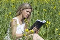 Young woman reading a book on the meadow Royalty Free Stock Photo