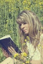 Young woman reading a book on the meadow Royalty Free Stock Photo