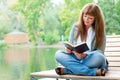 Young woman reading a book sitting on the bench Royalty Free Stock Photo