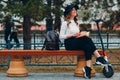 Young woman reading book and sitting on bench with electric scooter at the city Royalty Free Stock Photo