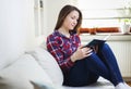 Young woman reading book on sofa relaxing at home Royalty Free Stock Photo