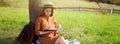 Young woman reading book under tree on meadow. Banner design Royalty Free Stock Photo