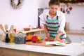 Young woman reading cookbook in the kitchen Royalty Free Stock Photo