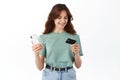 Young woman reading credit card number and paying online with smartphone, transfer money, using mobile banking app Royalty Free Stock Photo