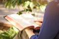 Joven mujer leer santo Biblia fuera 