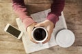 Young woman reading newspaper and holding coffee Royalty Free Stock Photo