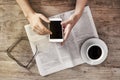 Young woman reading newspaper and holding phone Royalty Free Stock Photo