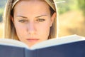 Young woman reading a paper book in nature Royalty Free Stock Photo